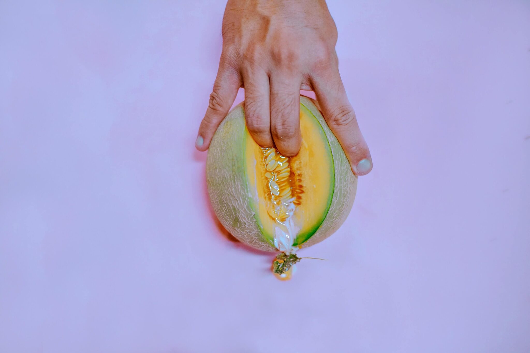 Dedos presionando un melón como metáfora visual del squirting